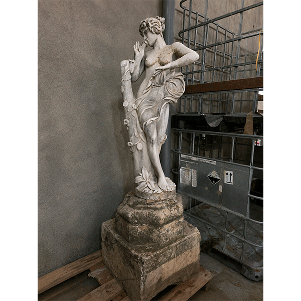 Figura femenina clásica de hormigón sobre base de piedra