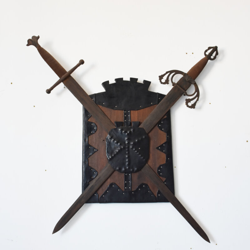 Panoplia decorativa medieval con escudo y dos espadas