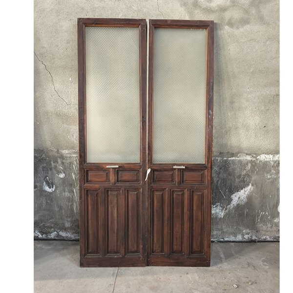 Antigua puerta doble de madera con cristales texturizados y cuarterones